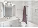 Bright bathroom featuring a bathtub with marble tile surround and a white vanity with elegant fixtures at 229 Dovecrest Nw Dr, Atlanta, GA 30305