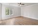 Bedroom with wood flooring, white trim, a ceiling fan, and a large window offering natural light at 229 Dovecrest Nw Dr, Atlanta, GA 30305