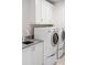 Functional laundry room featuring stacked washer and dryer, a utility sink, and white cabinetry at 229 Dovecrest Nw Dr, Atlanta, GA 30305