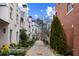 Beautiful street view showing lush landscaping between two rows of brick townhomes at 229 Dovecrest Nw Dr, Atlanta, GA 30305