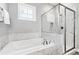 Stylish bathroom with separate soaking tub and glass-enclosed shower, featuring marble tile accents at 1311 English Nw St, Atlanta, GA 30318