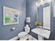 Charming powder room features blue walls, modern fixtures, and an elegant pedestal sink at 1311 English Nw St, Atlanta, GA 30318