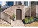 Close-up of a home's brick foundation, arched basement entrance, and professionally landscaped beds at 1311 English Nw St, Atlanta, GA 30318