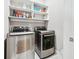 Laundry room with stainless steel washer and dryer and white shelves for ample storage at 1311 English Nw St, Atlanta, GA 30318