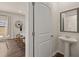 Elegant powder room with a pedestal sink and framed mirror with kitchen in the background at 204 Oak View Ln, Dallas, GA 30157