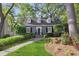 Charming two-story home featuring lush landscaping and a welcoming walkway leading to the front entrance at 560 Collier Nw Rd, Atlanta, GA 30318