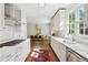 Bright kitchen with white cabinets, marble countertops, and stainless steel appliances, connecting to the dining area at 560 Collier Nw Rd, Atlanta, GA 30318