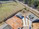 Aerial view of the home, featuring the driveway, partial landscaping, and adjacent undeveloped land at 144 Laurel Farms Ln, Dallas, GA 30157