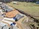 Overhead view of the home, with a long driveway, surrounded by partial landscaping and adjacent undeveloped land at 144 Laurel Farms Ln, Dallas, GA 30157