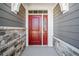 Close-up of the red front door with decorative trim and stone surround, creating a welcoming entrance at 144 Laurel Farms Ln, Dallas, GA 30157