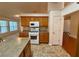 Bright kitchen with a tiled backsplash, modern appliances, and wood cabinets at 1854 Brittlebank Ln, Lawrenceville, GA 30043