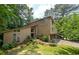 Charming home featuring a wood facade, an attached garage, mature trees and a meticulously landscaped front yard at 2235 Six Branches Dr, Roswell, GA 30076