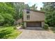 Two-story home with a two-car garage, a front yard, and mature trees at 2235 Six Branches Dr, Roswell, GA 30076