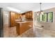 Open kitchen with wooden cabinets, tile flooring, and a view of the surrounding greenery at 2235 Six Branches Dr, Roswell, GA 30076