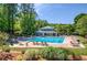 Community pool area with inviting blue water, lounge chairs, and a well-maintained deck surrounded by trees at 2235 Six Branches Dr, Roswell, GA 30076