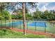 View of the community tennis courts framed by mature trees and landscaping at 2235 Six Branches Dr, Roswell, GA 30076