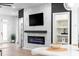 Living room with a marble accent wall, fireplace, shelving, flat screen tv, and light hardwood floors at 1084 Brookglynn Trce, Decatur, GA 30032