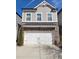 Two-story townhome with a brick facade, attached garage, and modern architectural details at 3615 Faulkner St, Cumming, GA 30041