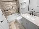 Modern bathroom with a tiled shower over tub, floating shelves, and stone patterned floors at 5920 Rock Rd, Union City, GA 30291