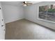 A carpeted bedroom with a ceiling fan and large window providing natural light at 5920 Rock Rd, Union City, GA 30291