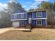 Charming two-story home with blue siding, white trim, shutters and an attached garage at 5920 Rock Rd, Union City, GA 30291