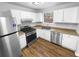 Well-lit kitchen featuring stainless steel appliances, white cabinets, and wood look flooring at 5920 Rock Rd, Union City, GA 30291