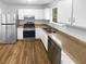 Well-lit kitchen featuring stainless steel appliances, white cabinetry, and wood-look flooring at 5920 Rock Rd, Union City, GA 30291