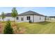 Home's backyard features a lawn, small patio, and young trees at 8601 Secretariat Dr, Lithonia, GA 30058