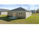 A backyard featuring green grass, a small cement pad, and the rear exterior of a single-story home at 8601 Secretariat Dr, Lithonia, GA 30058