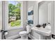 Bathroom with white toilet and white basin sink, with window that has an outdoor view at 2150 Tidwell Ln # 5, Atlanta, GA 30318