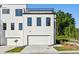 Rear view of a modern townhome with a garage and a rooftop deck on a sunny day at 2150 Tidwell Ln # 5, Atlanta, GA 30318