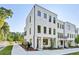 Modern, three-story white brick townhome featuring black-framed windows and manicured landscaping at 2150 Tidwell Ln # 5, Atlanta, GA 30318