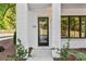 Inviting front entrance of a white-brick townhome with a modern black door and landscaping at 2150 Tidwell Ln # 5, Atlanta, GA 30318