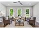 Living room featuring light gray walls, three windows, ceiling fan, neutral furniture, and dark hardwood floors at 2150 Tidwell Ln # 5, Atlanta, GA 30318