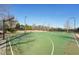 Community basketball court with green surface, white lines and basketball hoops under a clear blue sky at 807 Plaintain Dr, Woodstock, GA 30188