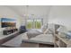 Bright bedroom featuring a tufted bed, a chandelier, large windows, and a sitting area with a stylish armchair at 807 Plaintain Dr, Woodstock, GA 30188