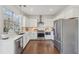 Bright kitchen features white cabinets, stainless steel appliances, undermount sink, and hardwood floors at 807 Plaintain Dr, Woodstock, GA 30188