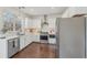 Bright kitchen features white cabinets, stainless steel appliances, undermount sink, and hardwood floors at 807 Plaintain Dr, Woodstock, GA 30188