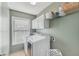 Functional laundry room featuring a front-load washer and dryer, white cabinets, and a built-in shelf for storage at 807 Plaintain Dr, Woodstock, GA 30188