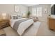 Well-lit bedroom featuring a bed with linens, side tables, art and a sitting area near a window at 6420 Magnolia Way, Morrow, GA 30260