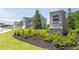 Landscaped community entrance with stone sign and flowering shrubs near the road at 8591 Seabiscuit Rd, Lithonia, GA 30058