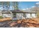 Rear exterior showcasing white siding and black framed windows against the backdrop of natural landscaping at 1180 Fleming St, Atlanta, GA 30080