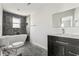 Bathroom featuring a modern tub, dark tile accent wall, and a sleek vanity with sink and mirror at 1180 Fleming St, Atlanta, GA 30080
