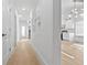 Bright hallway leading to a modern kitchen with sleek, white cabinets and appliances at 1557 Alder Se Ct, Atlanta, GA 30317