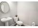 Bathroom featuring a pedestal sink, oval mirror, and toilet at 18 Village Trce, Rydal, GA 30171