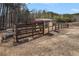 View of fenced shed featuring a brown wooden frame, a metal roof, and an enclosed run at 18 Village Trce, Rydal, GA 30171