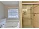 Bright bathroom with a large window, soaking tub, and glass-enclosed shower at 2506 Creek Station Dr, Buford, GA 30519