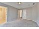 Large carpeted bedroom featuring neutral walls, natural light, and bathroom access at 2506 Creek Station Dr, Buford, GA 30519