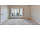 This bright bedroom has neutral carpeting and a view of the front yard at 2506 Creek Station Dr, Buford, GA 30519
