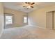 Bright bedroom with ceiling fan, neutral carpet and natural light from two windows at 2506 Creek Station Dr, Buford, GA 30519